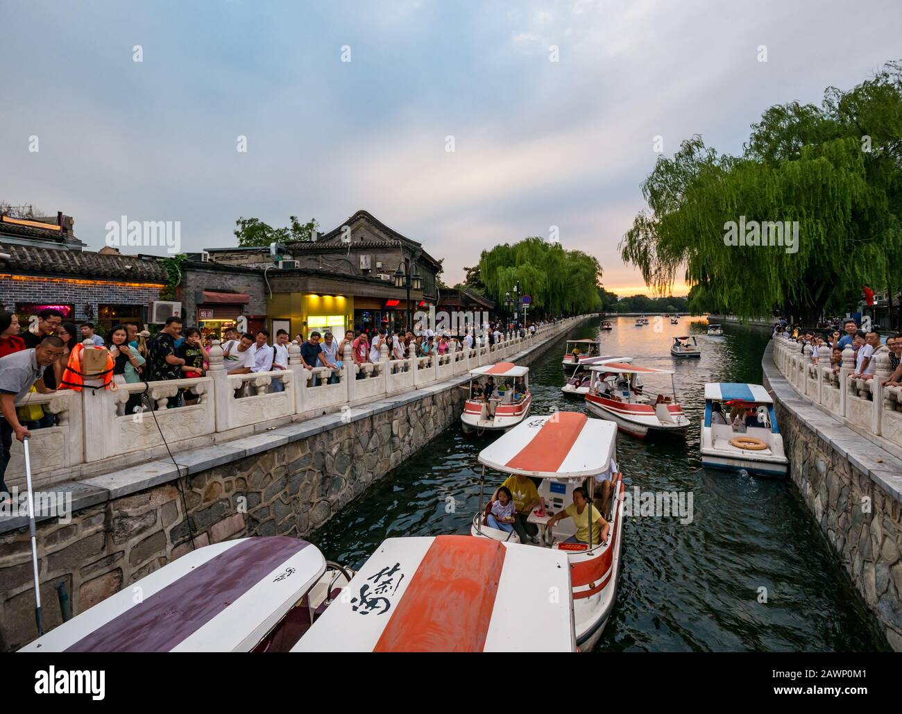 Un bateau à pédales se coince au pont au coucher du soleil, le lac impérial Houhai, le district de Xi Cheng Hutong, Beijing, Chine, Asie Banque D'Images