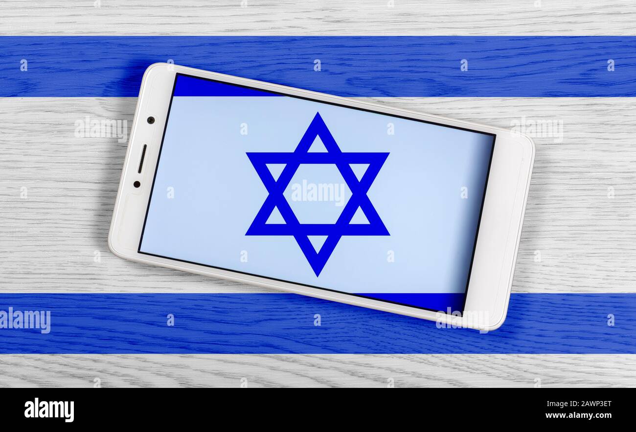 Drapeau d'Israël composé en plaçant un smartphone affichant son symbole sur un fond en bois coloré Banque D'Images