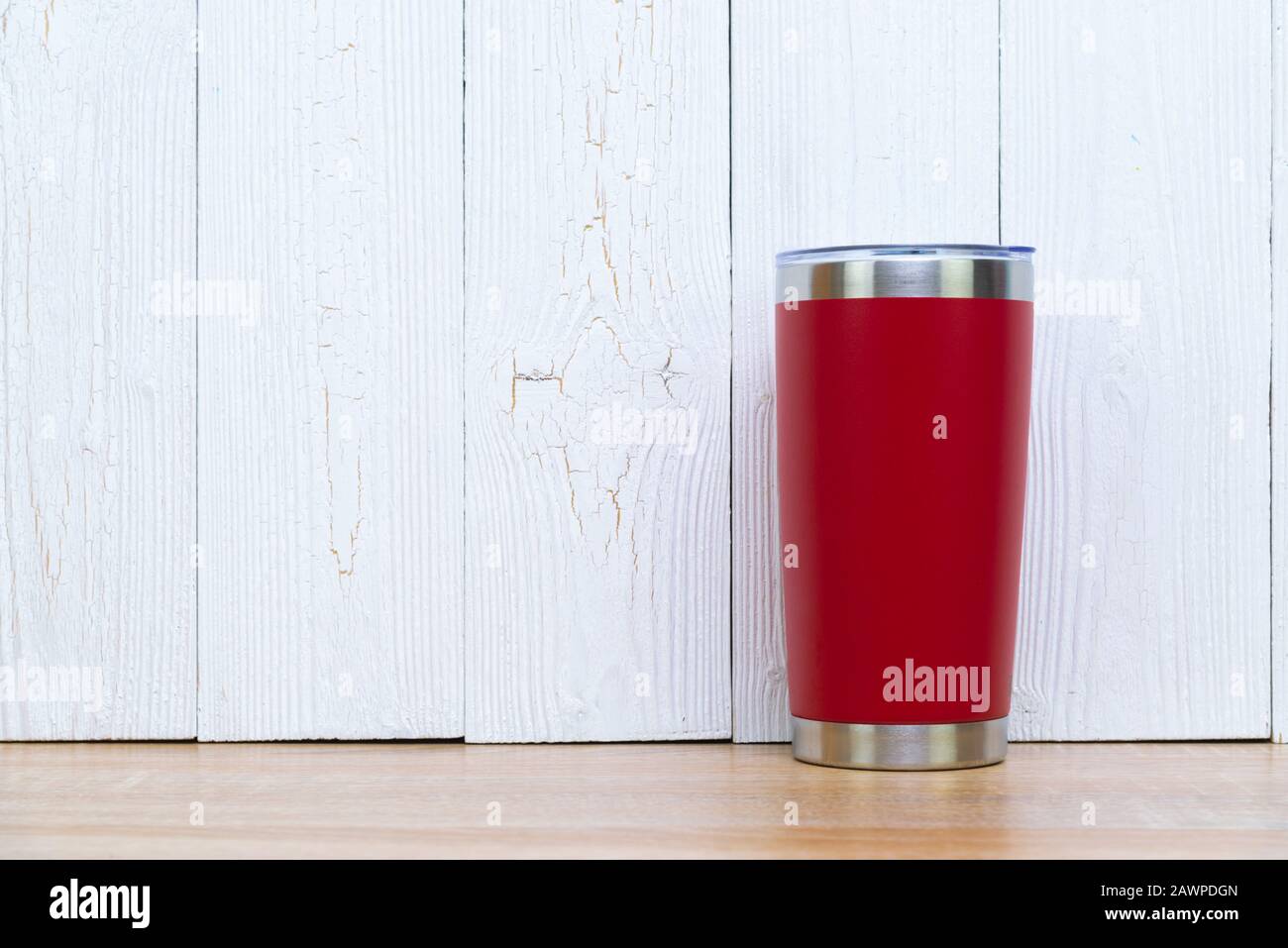 Acier inoxydable couleur rouge gobelet ou tasse de stockage à froid et à chaud sur fond de bois. Banque D'Images
