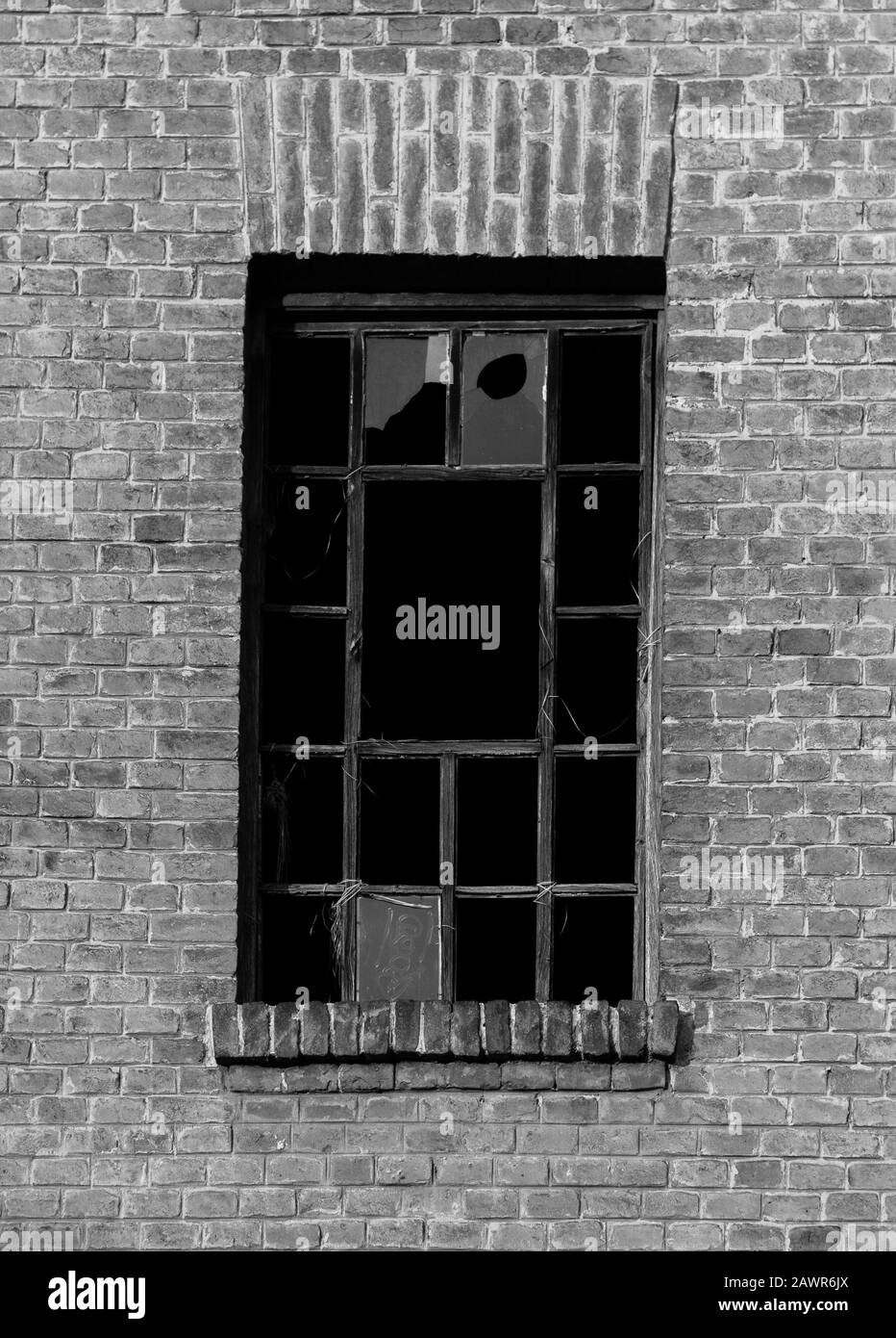 Vue en échelle de gris des fenêtres brisées d'un ancien bâtiment Banque D'Images
