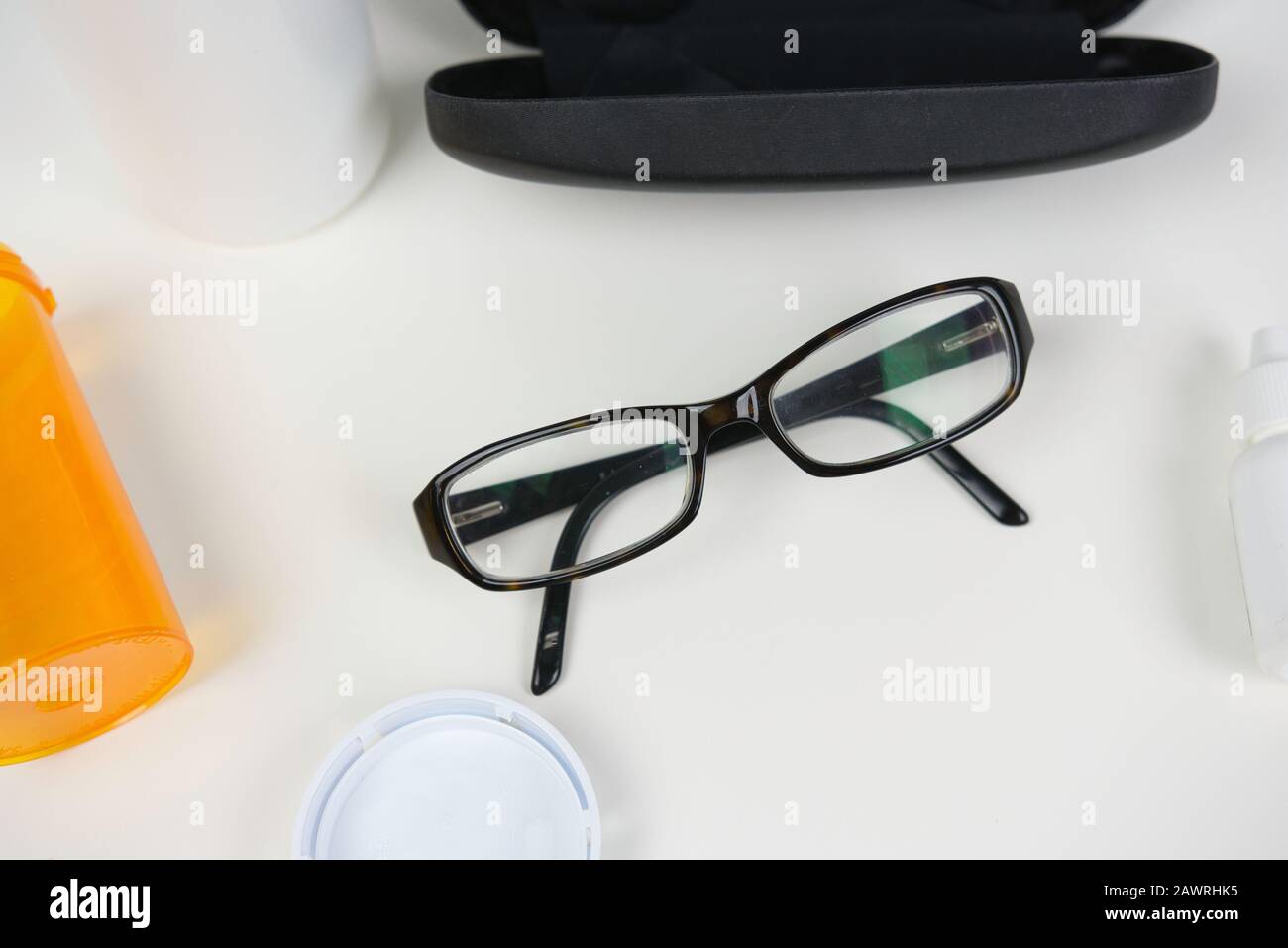 Lunettes sur comptoir blanc avec divers produits de soin des yeux. Pose plate de fournitures médicales pour les soins de la vision Banque D'Images