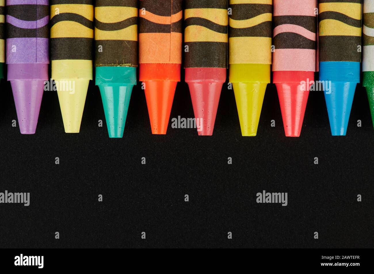 Les enfants peignent la vue rapprochée de l'outil crayon sur fond noir Banque D'Images