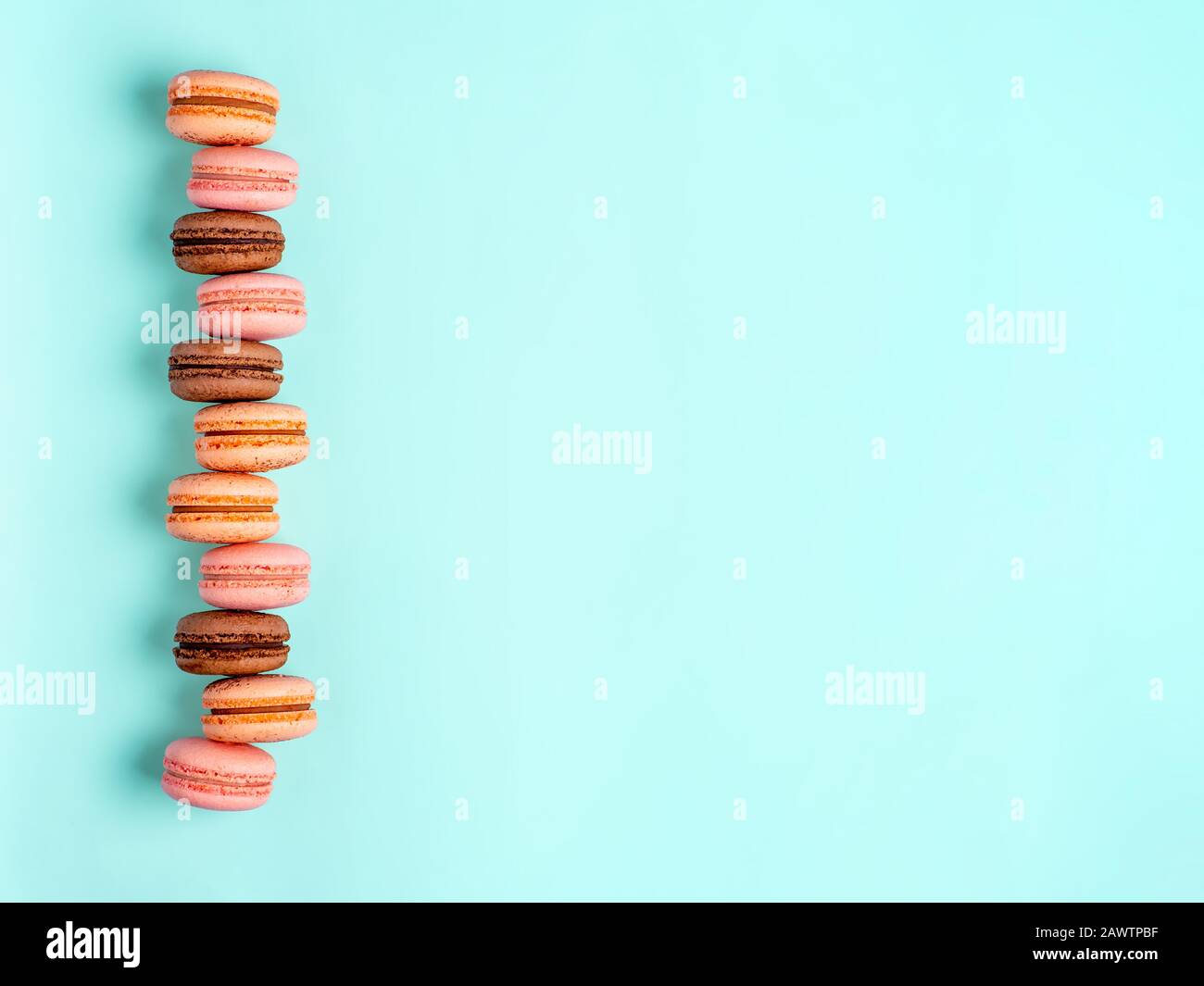 Macarons avec espace de copie. Rangée de macarons ou macarons français parfaits sur fond bleu. Vue de dessus ou plat Banque D'Images