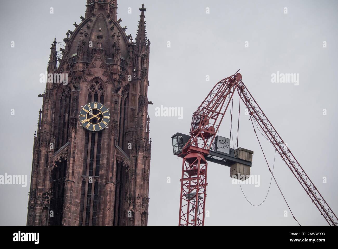 10 février 2020, Hessen, Francfort-sur-le-Main: Le djib d'une grue de bâtiment, qui a été tordue par la tempête 'STIB', est coincé dans le toit de la cathédrale de Francfort. La dépression de tempête 'STabine' balaie encore l'Allemagne avec des vitesses de vent en partie très élevées. Photo: Boris Roessler/Dpa Banque D'Images