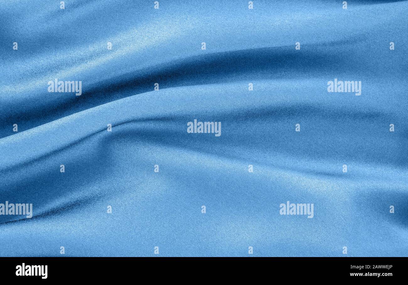 Tissu bleu en soie naturelle toile de fond ondulée draperie. Tendance des couleurs de l'année 2020. Banque D'Images