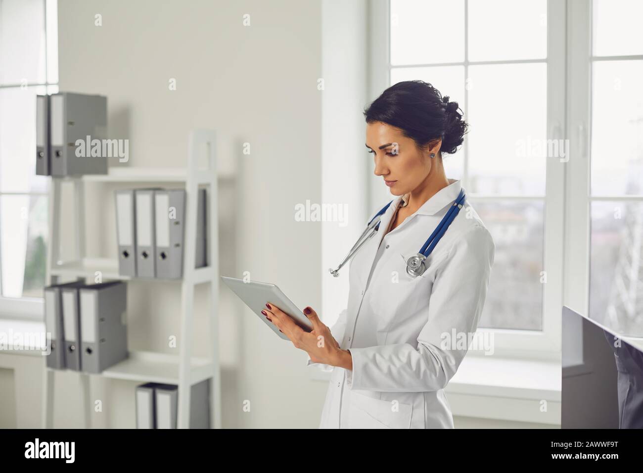 Femme médecin pédiatre debout dans le bureau blanc de l'hôpital. Banque D'Images