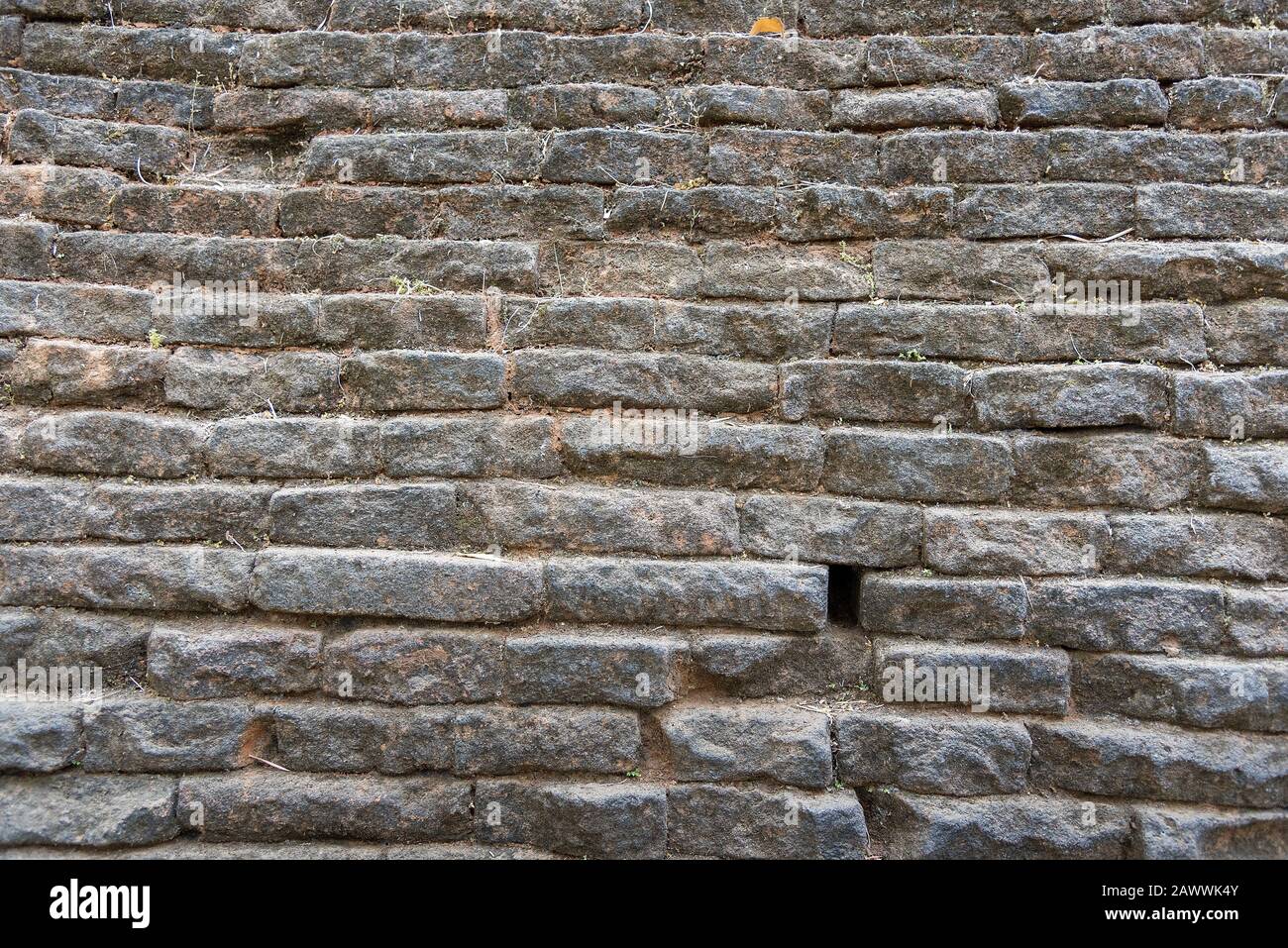 Mur de granit composé de couches de dalles fixées en place avec mortier rugueux d'argile. Texture répétée. Banque D'Images