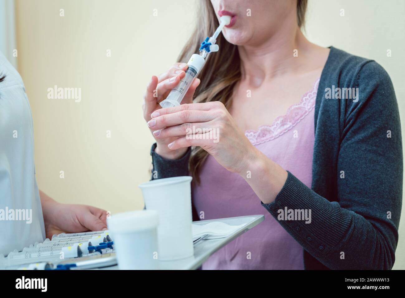 Femme en respiration à l'hôpital dans le tube pour tester la maladie respiratoire Banque D'Images