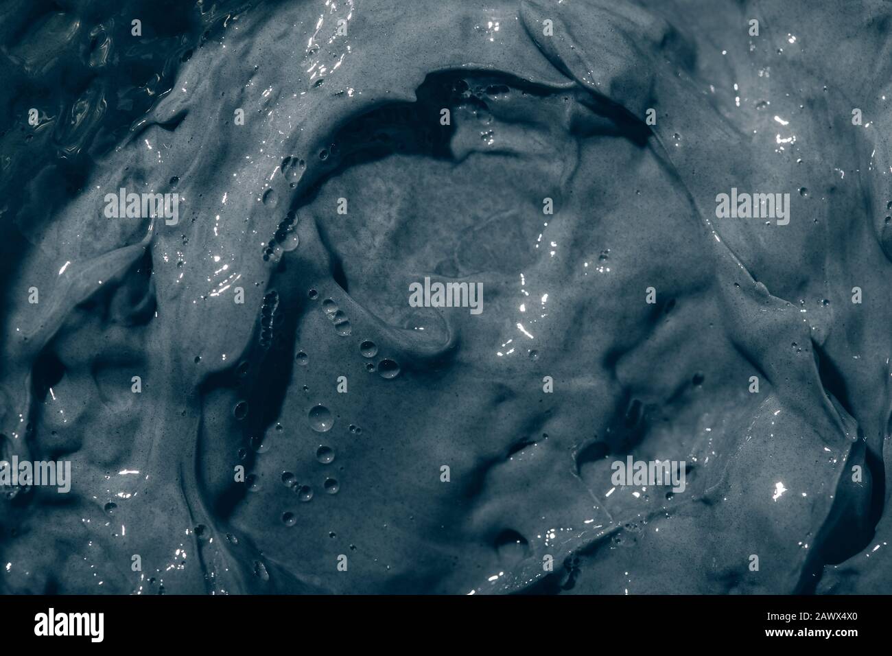 Texture de la crème de masque d'argile noire sur le visage et le corps. Nettoyage des soins de la peau de près. Contexte. Banque D'Images