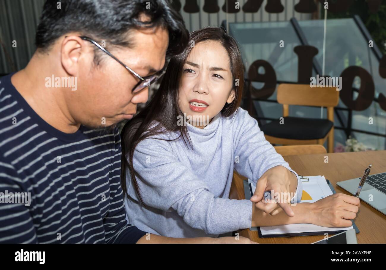 Une femme d'affaires intelligente asiatique discute sérieusement d'un argument sur le travail avec un homme d'affaires portant un costume moderne informel au bureau de l'espace de travail Banque D'Images