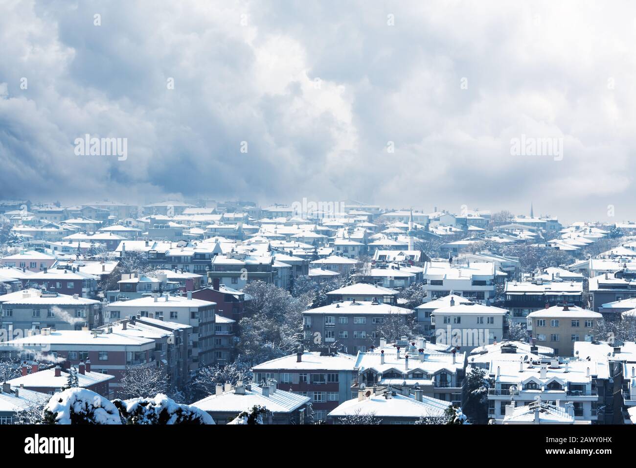 Vue sur la ville couverte de neige par le dessus et un ciel gris nuageux arrière-plan en hiver Banque D'Images