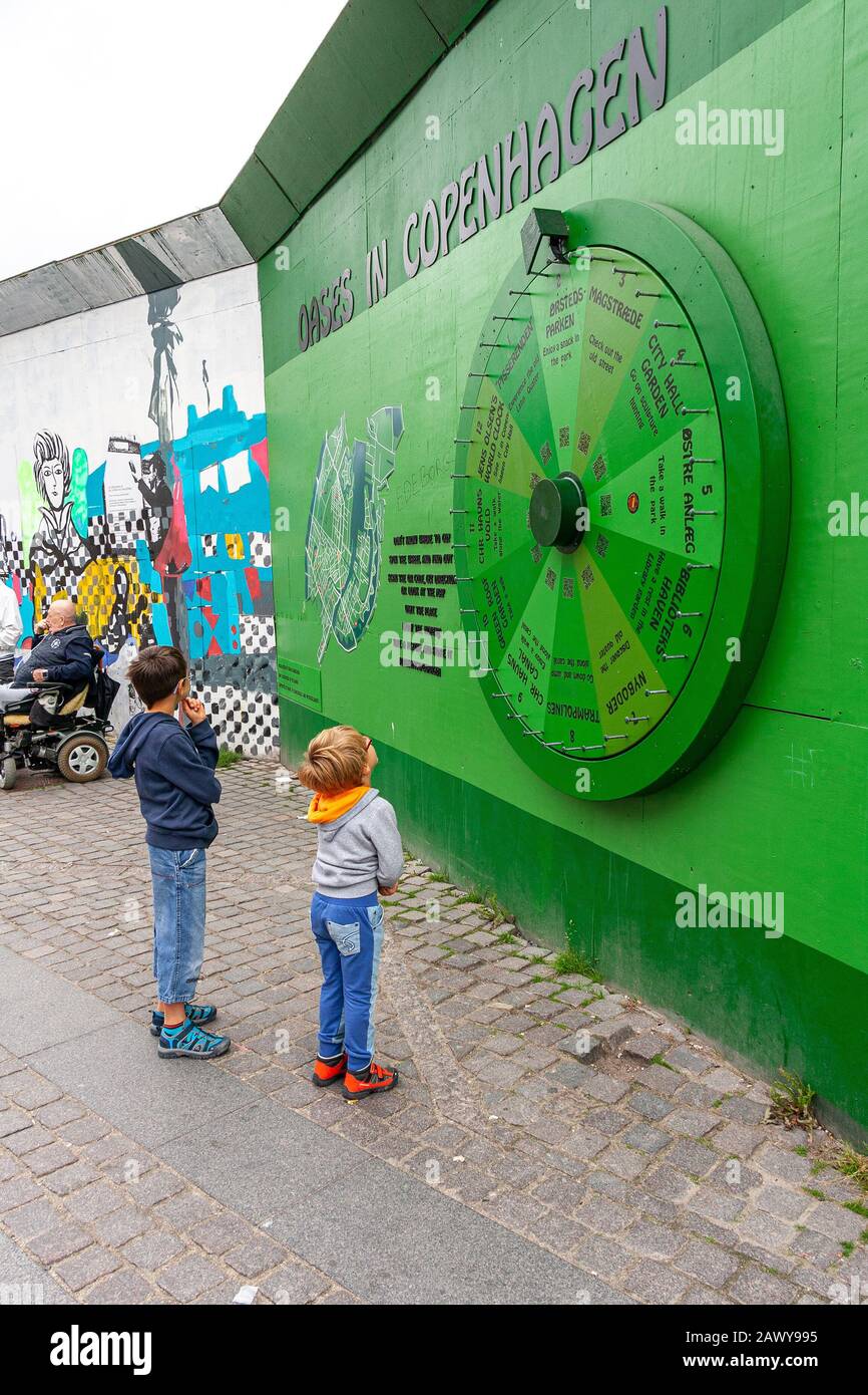 Deux enfants observent le point d'information de la ville de Copenhague. L'invitation est de chercher où aller en tournant le volant. Danemark Banque D'Images