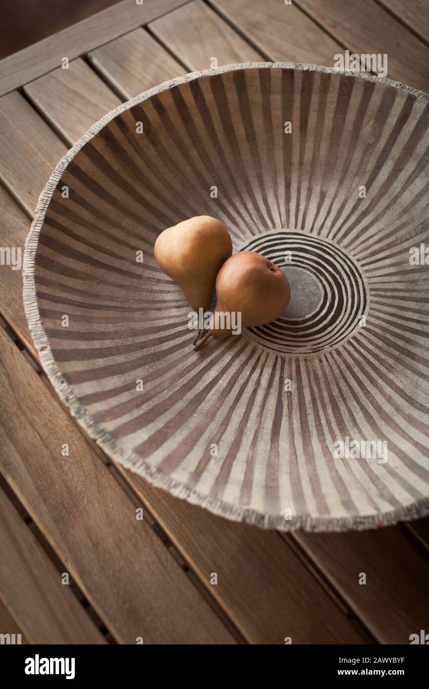 Toujours faire la vie des poires dans un bol en céramique avec le motif sur la table en bois Banque D'Images