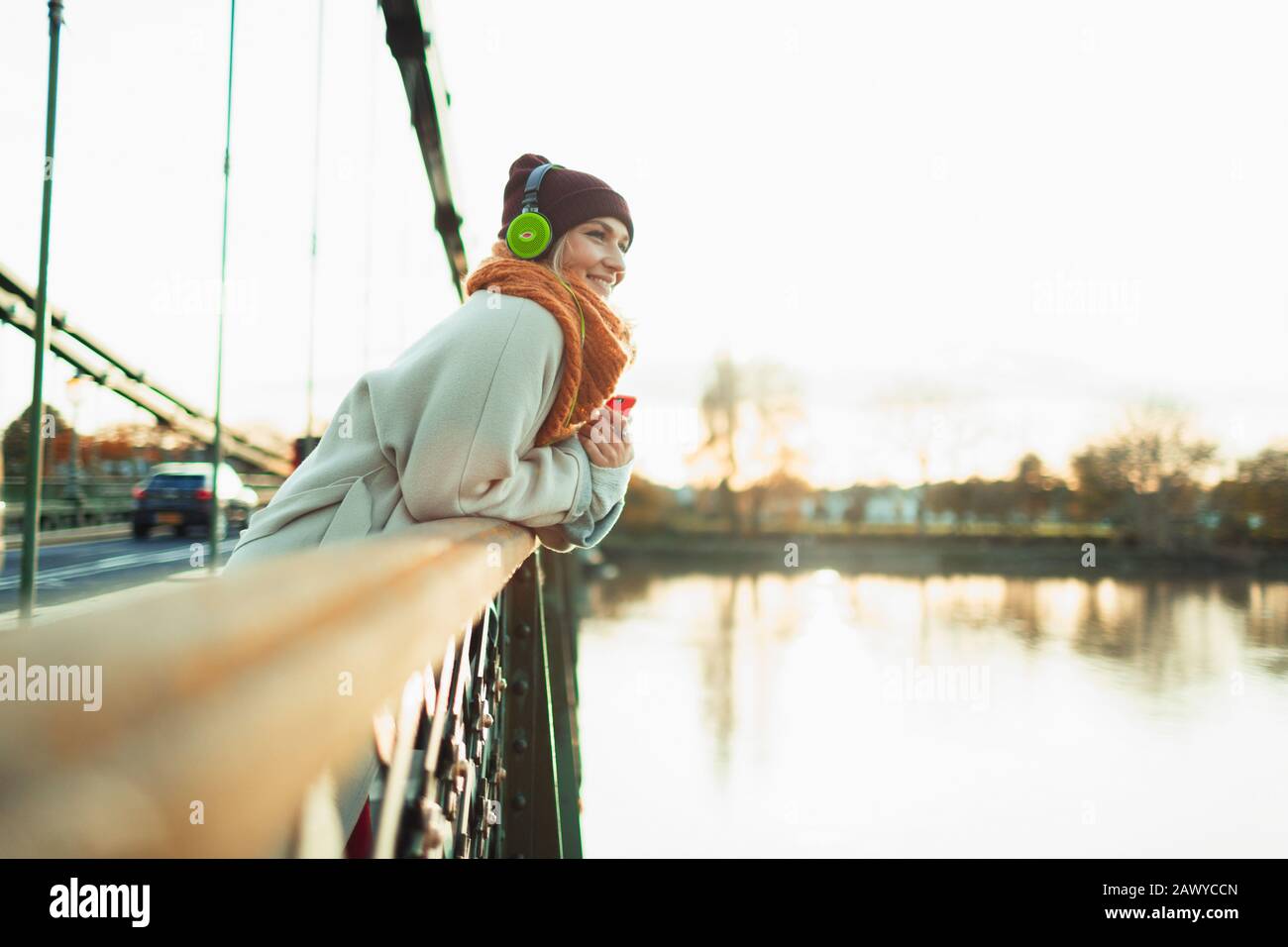 Femme insouciante écoutant de la musique avec casque sur le pont d'automne Banque D'Images