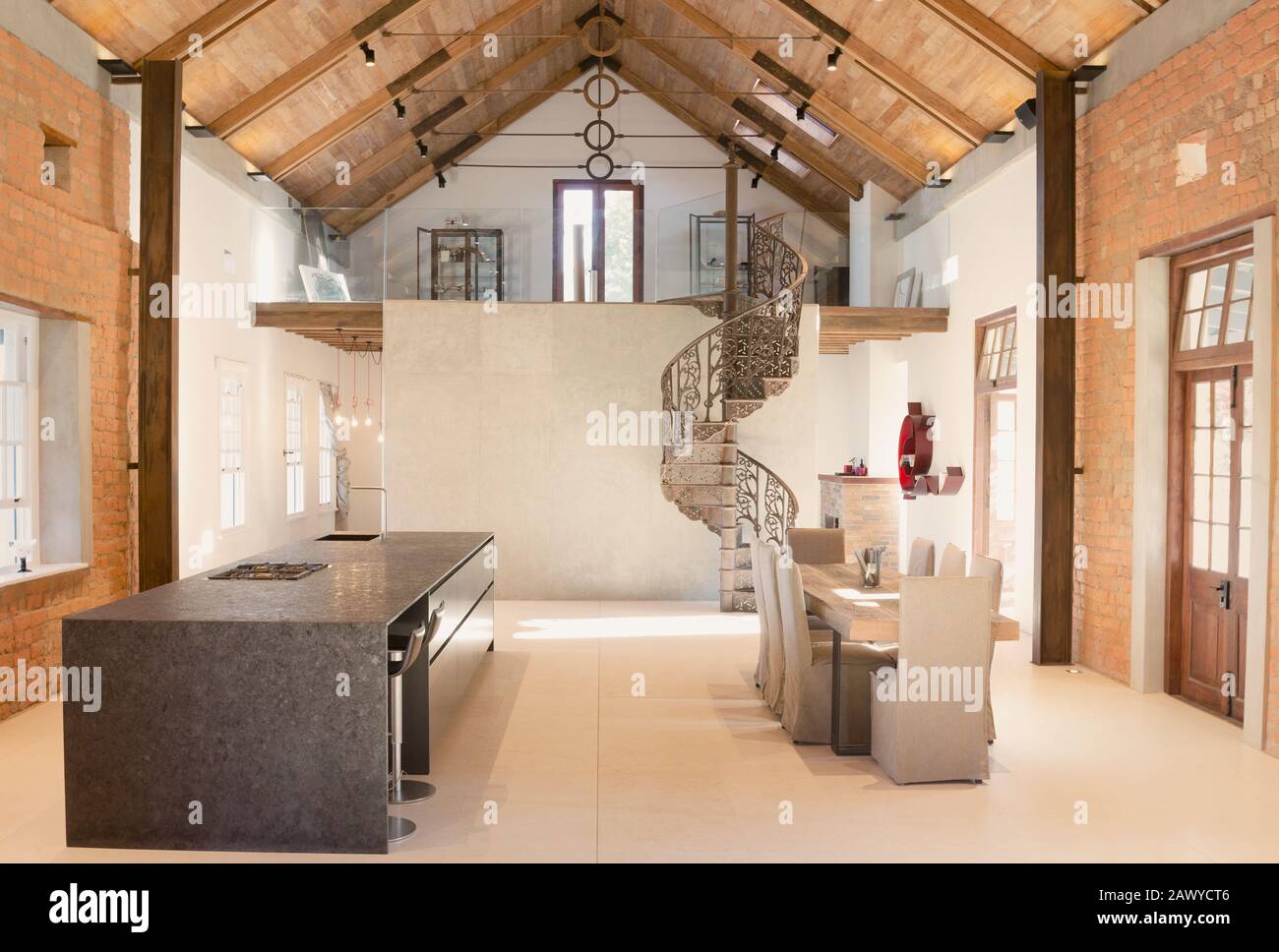 La maison présente salle à manger intérieure avec plafond voûté en bois et loft en escalier en spirale Banque D'Images