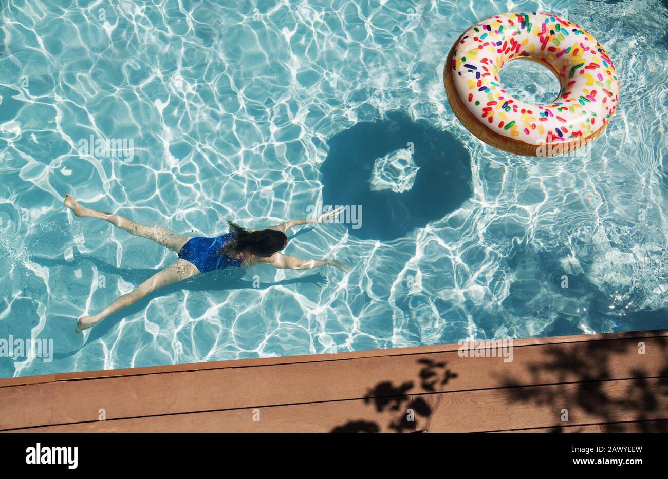 Fille nageant sous l'eau dans la piscine ensoleillée Banque D'Images