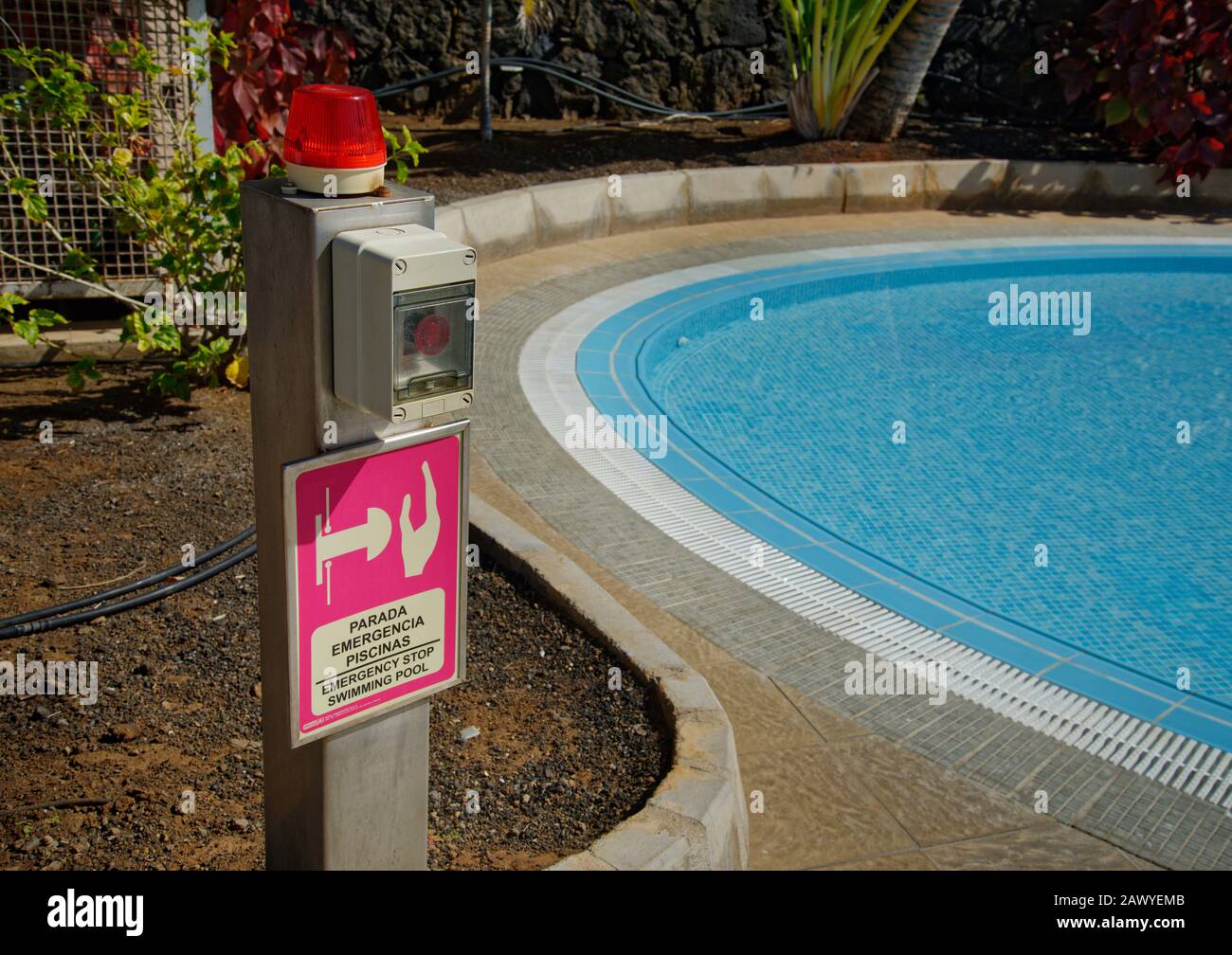 Bouton d'arrêt d'urgence de la piscine, avec piscine bleue à côté. Banque D'Images