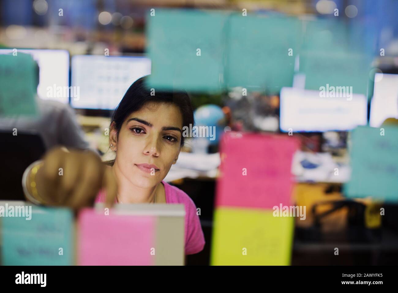Femme d'affaires dédiée avec planification de notes adhésives au bureau Banque D'Images