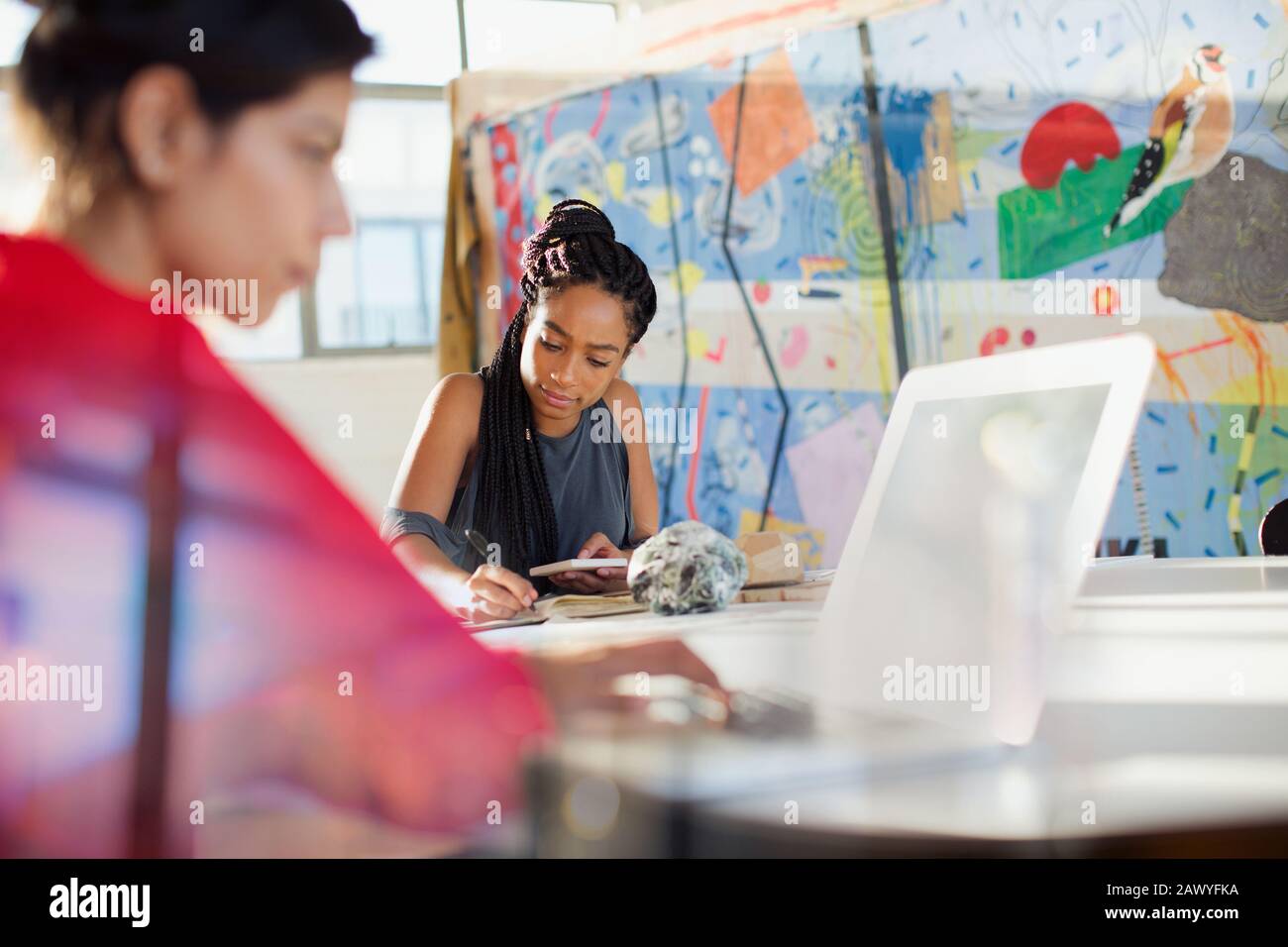 Des femmes d'affaires créatives concentrées travaillant au bureau Banque D'Images