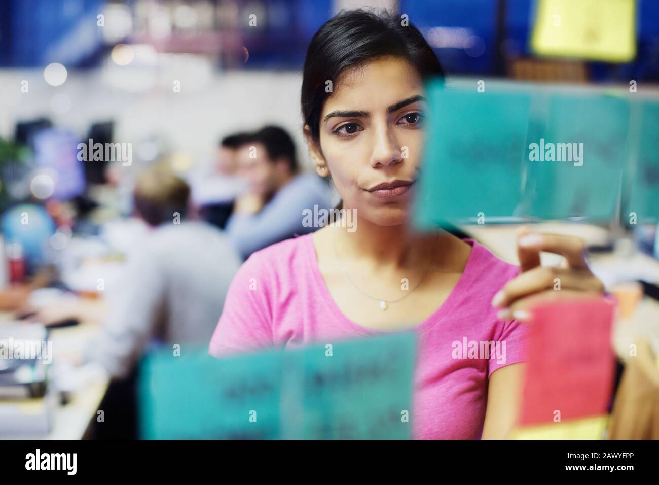 Femme d'affaires ciblée avec planification de notes adhésives au bureau Banque D'Images