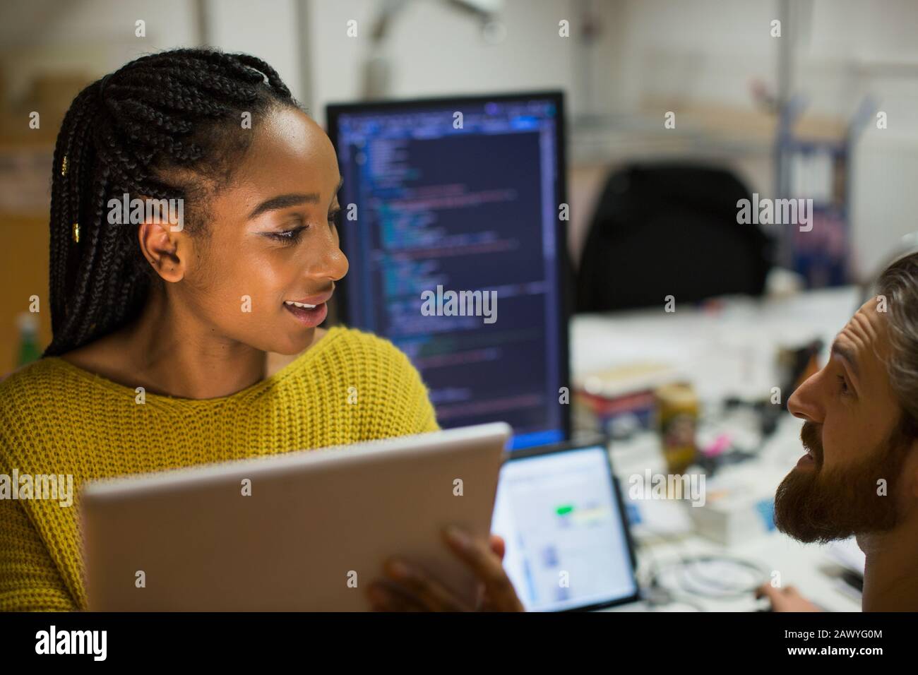 Programmeurs informatiques avec tablette numérique parlant au bureau Banque D'Images