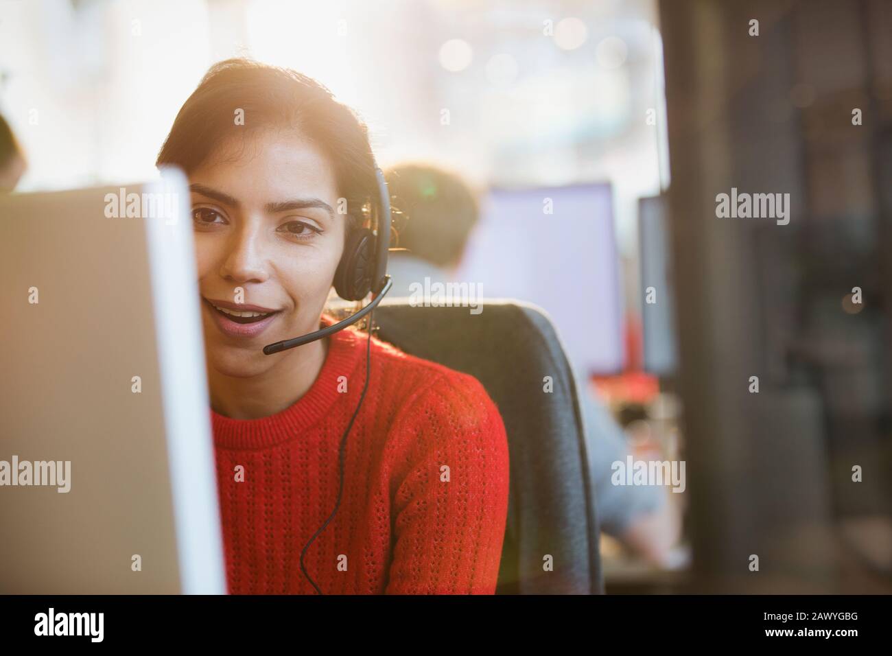 Femme d'affaires travaillant dans un micro-casque/une oreillette au bureau Banque D'Images