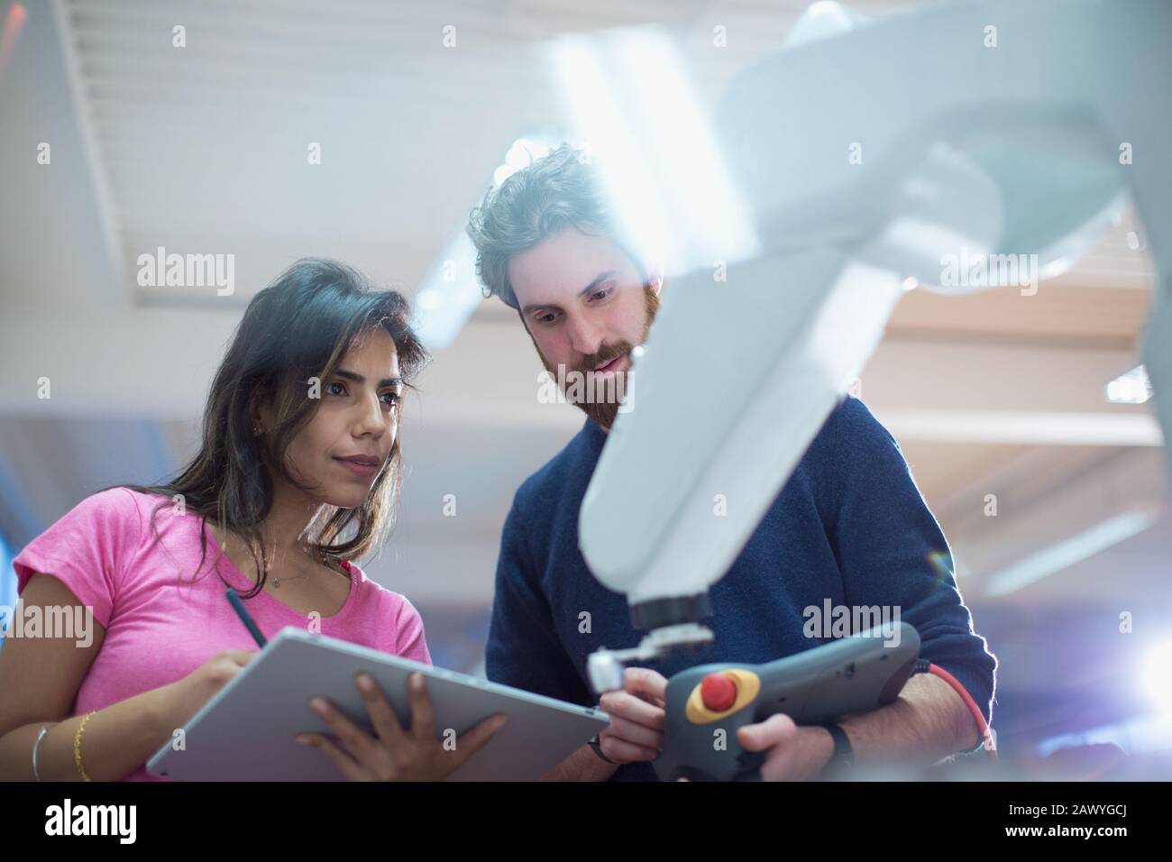 Ingénieurs avec bras robotisé de programmation de tablette numérique au bureau Banque D'Images