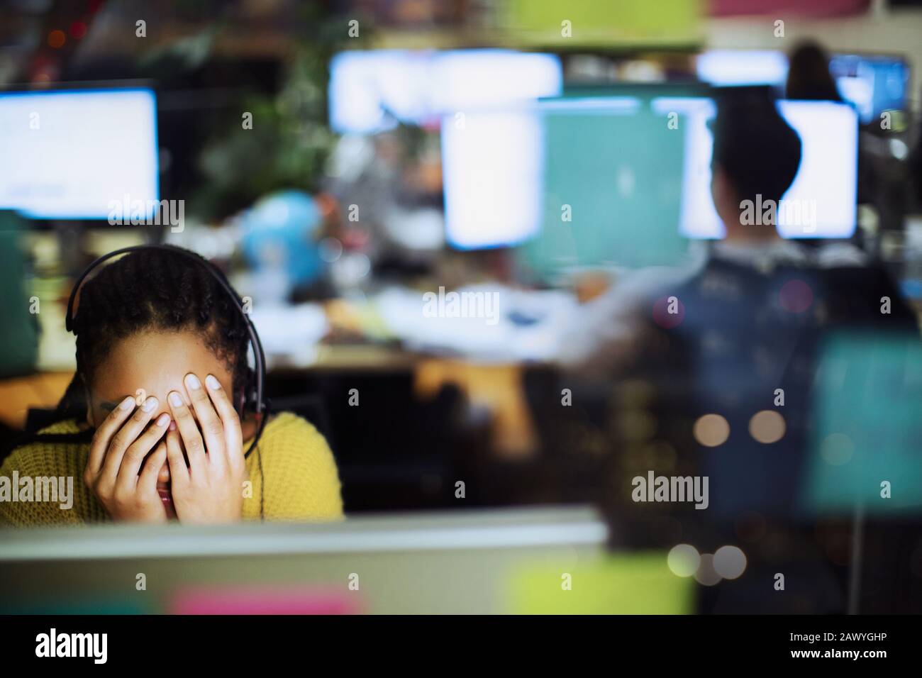 Fatiguée, femme d'affaires stressée avec la tête dans les mains à l'ordinateur au bureau Banque D'Images
