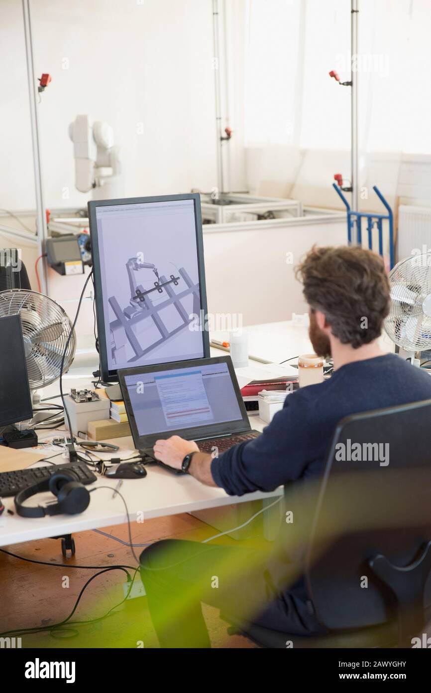 Robotique de programmation d'ingénieur masculin, travaillant sur un ordinateur portable au bureau Banque D'Images