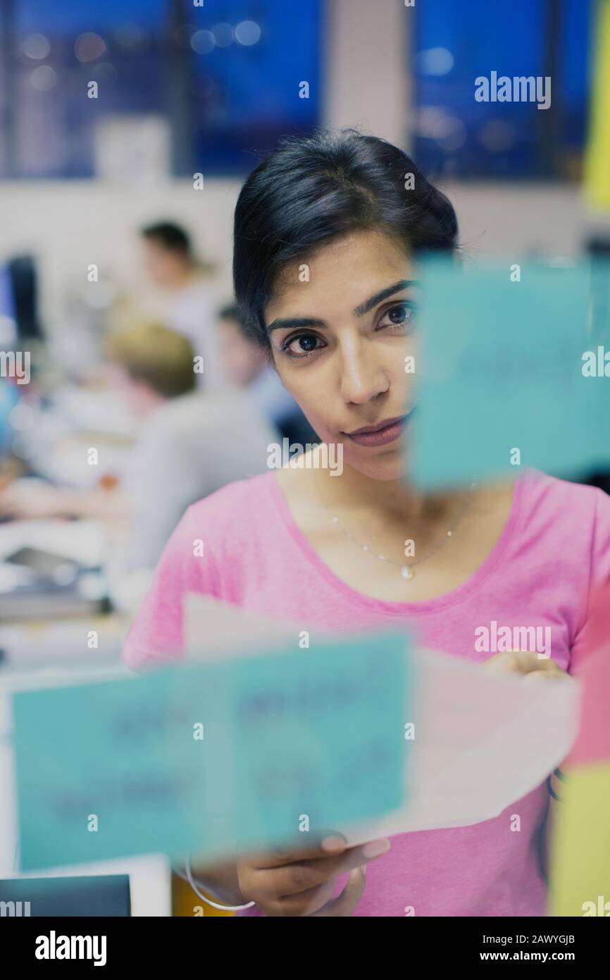 Planification centrée des femmes d'affaires, en regardant les notes adhésives au bureau Banque D'Images