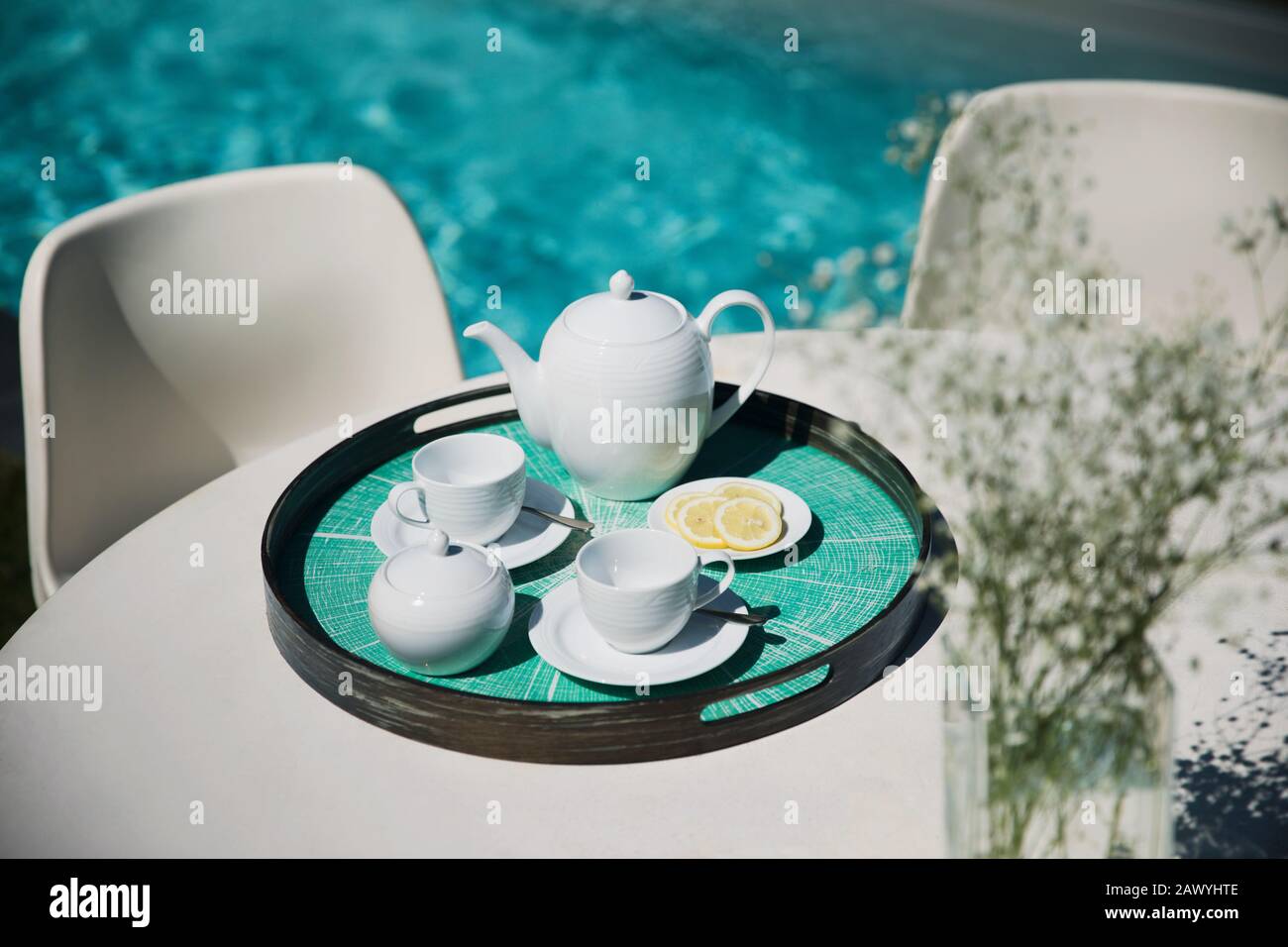 Service de thé sur la table de terrasse ensoleillée de la piscine Banque D'Images