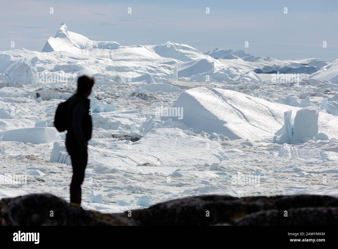 Silhouette homme regardant la glace glaciale ensoleillée fondre Groenland Banque D'Images
