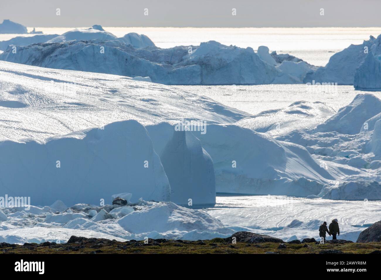 Les gens font de la randonnée le long du glacier ensoleillé de fonte Groenland Banque D'Images