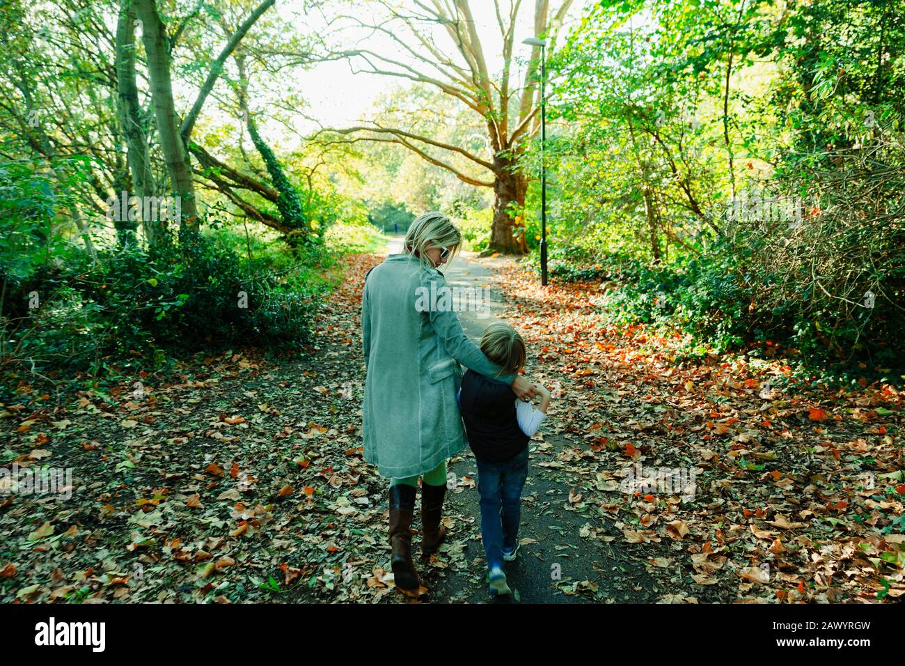Mère et fils marchant dans un parc idyllique d'automne Banque D'Images