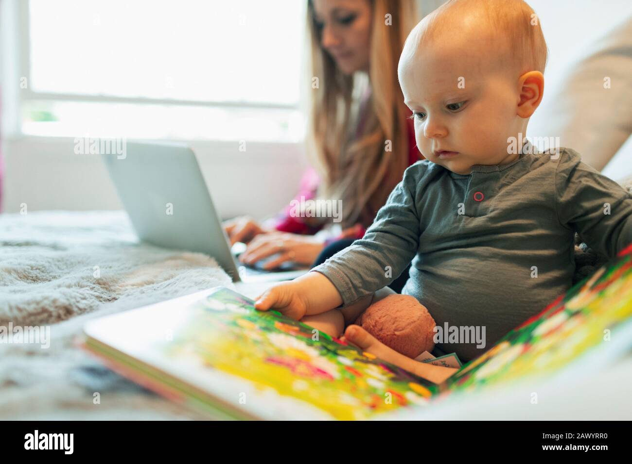 Jolie fille curieux de bébé lecture livre d'image Banque D'Images