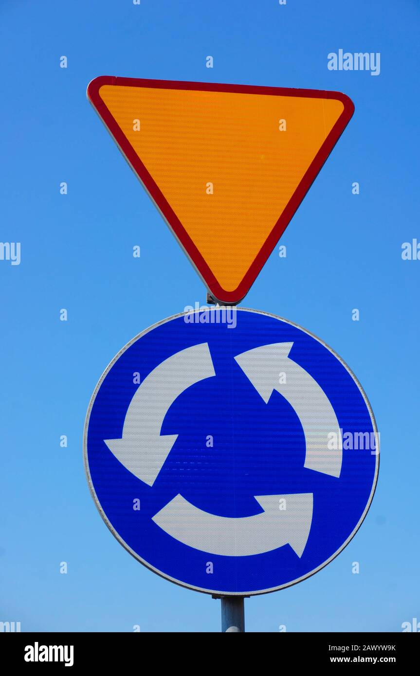 Gros plan vertical des panneaux de signalisation indiquant un mouvement circulaire et rendement Banque D'Images