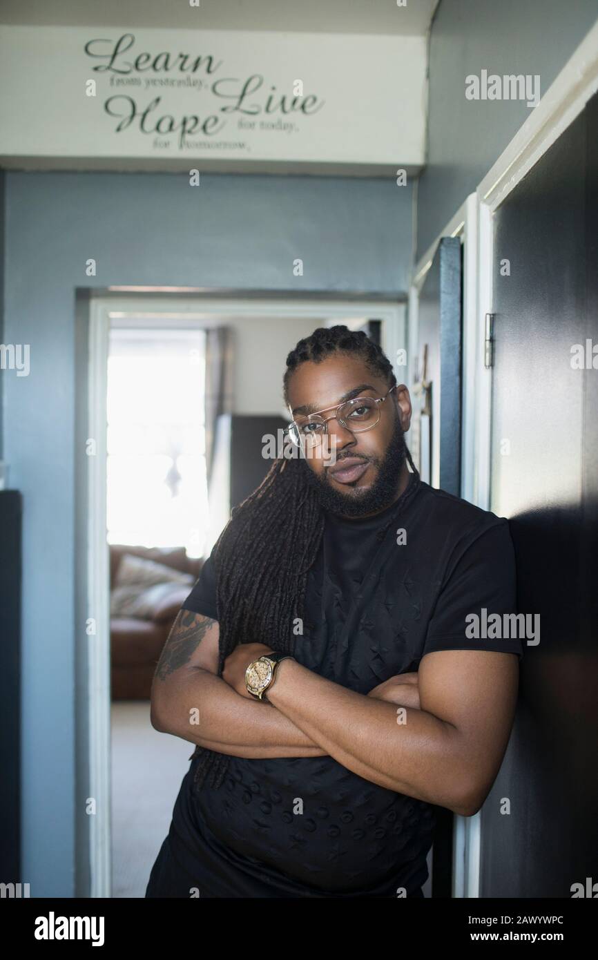 Portrait confiant cool homme avec de longues tresses dans le couloir Banque D'Images