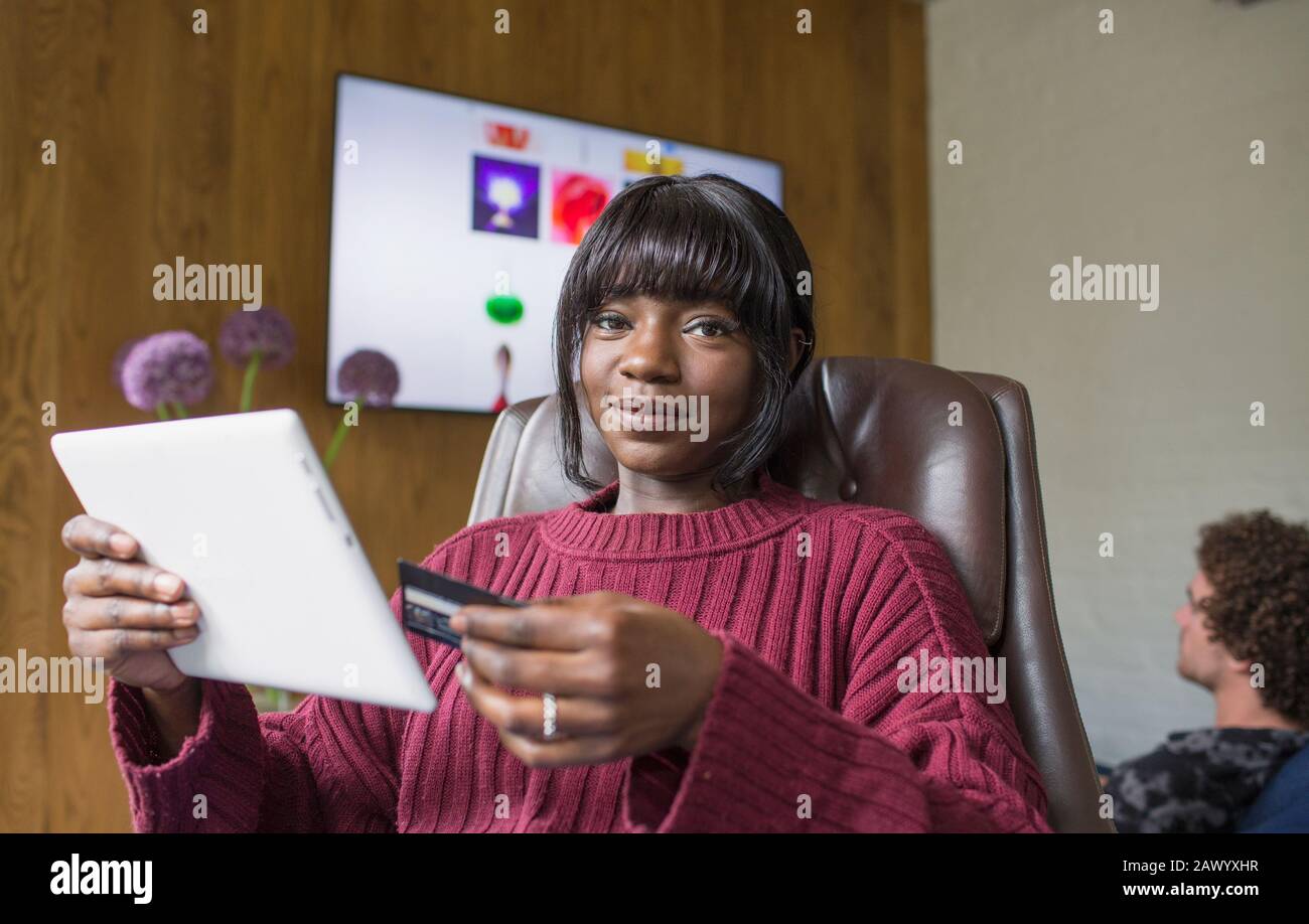 Portrait jeune femme shopping en ligne avec tablette numérique et carte de crédit Banque D'Images