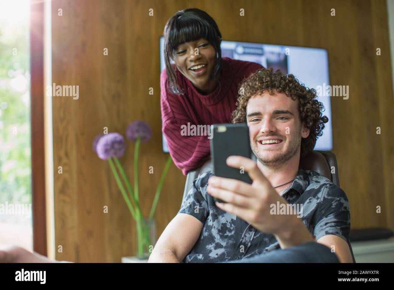 Happy young couple using smart phone Banque D'Images