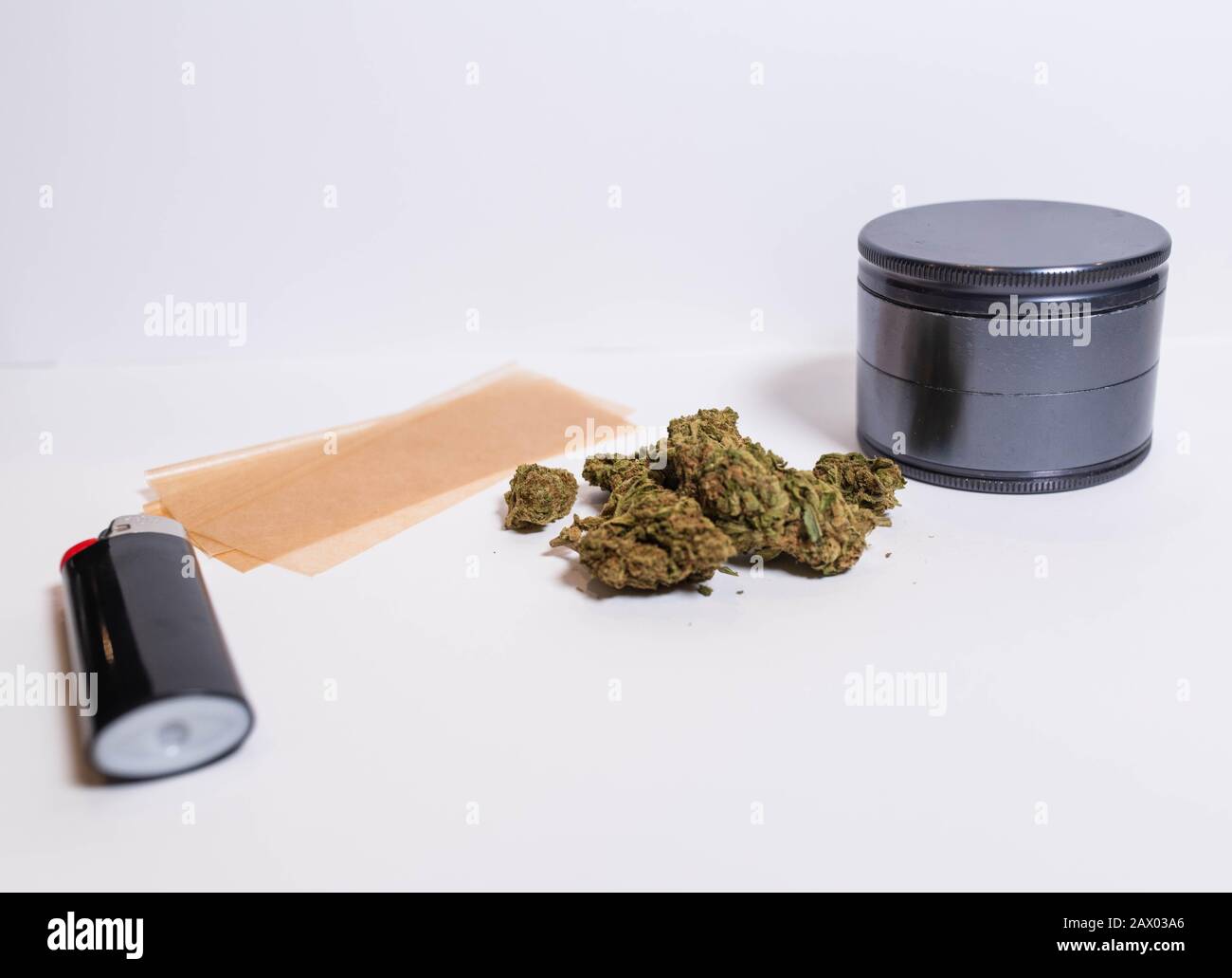 Fournitures pour rouler un joint avec un papier roulant plus léger, des tasses de marijuana, et une meuleuse pour moudre la mauvaise herbe. Banque D'Images