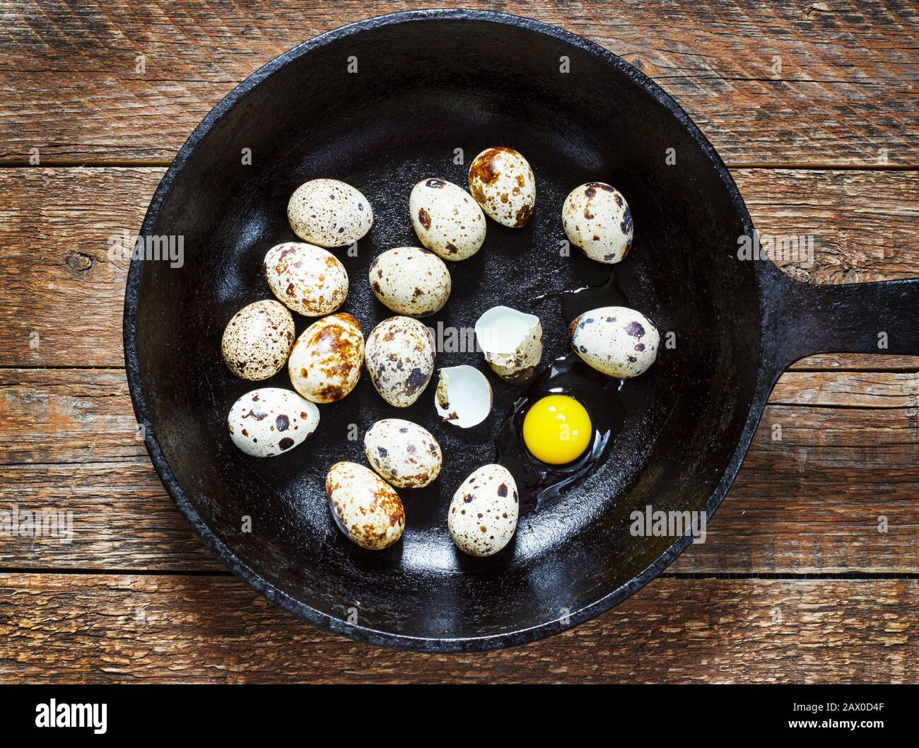 œufs quail dans une poêle en fonte sur une vieille table en bois, style rétro Banque D'Images