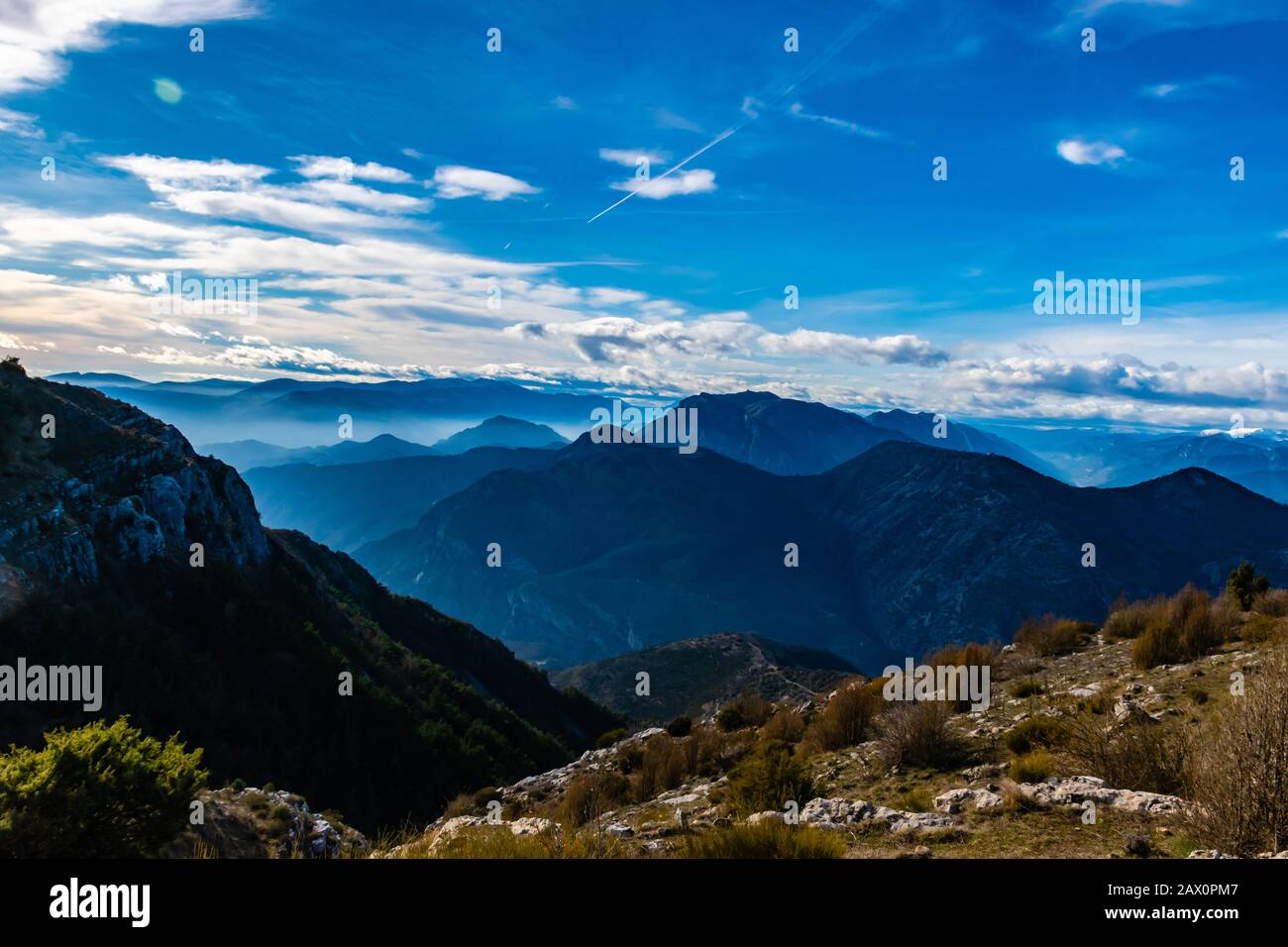 Magnifique paysage captivant de la chaîne de montagnes des Alpes françaises brumeuses en couches dans les Alpes-Maritimes l'après-midi pendant une journée ensoleillée Banque D'Images