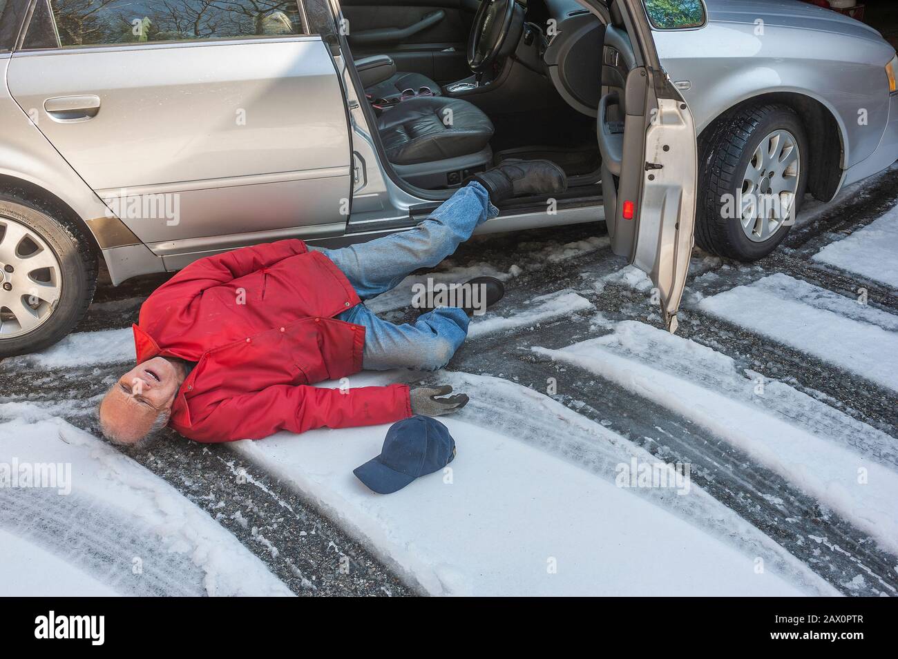 L'homme principal a glissé sur la glace en sortant de sa voiture Banque D'Images