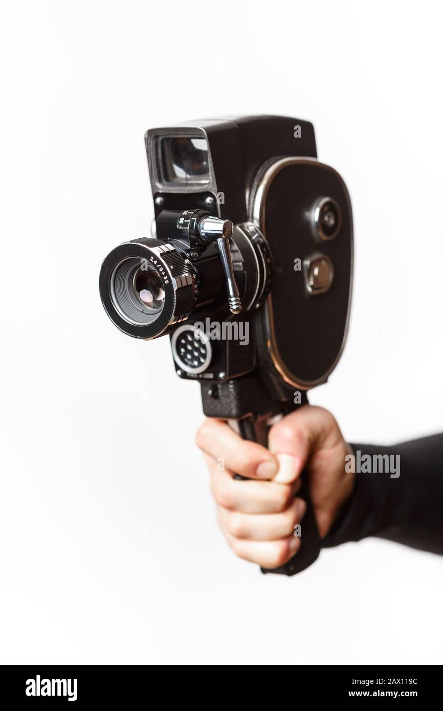 Main féminine tenant l'ancienne caméra vidéo 8 mm isolée sur un fond blanc Banque D'Images