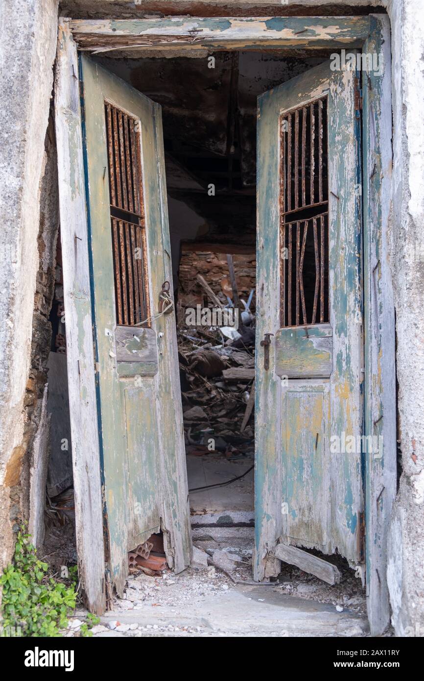 Ancienne porte double ouverte détruite. Porte en bois, épluchée, déverrouillée dans une maison abandonnée et ruinée. Risque de chute, vue verticale. Banque D'Images