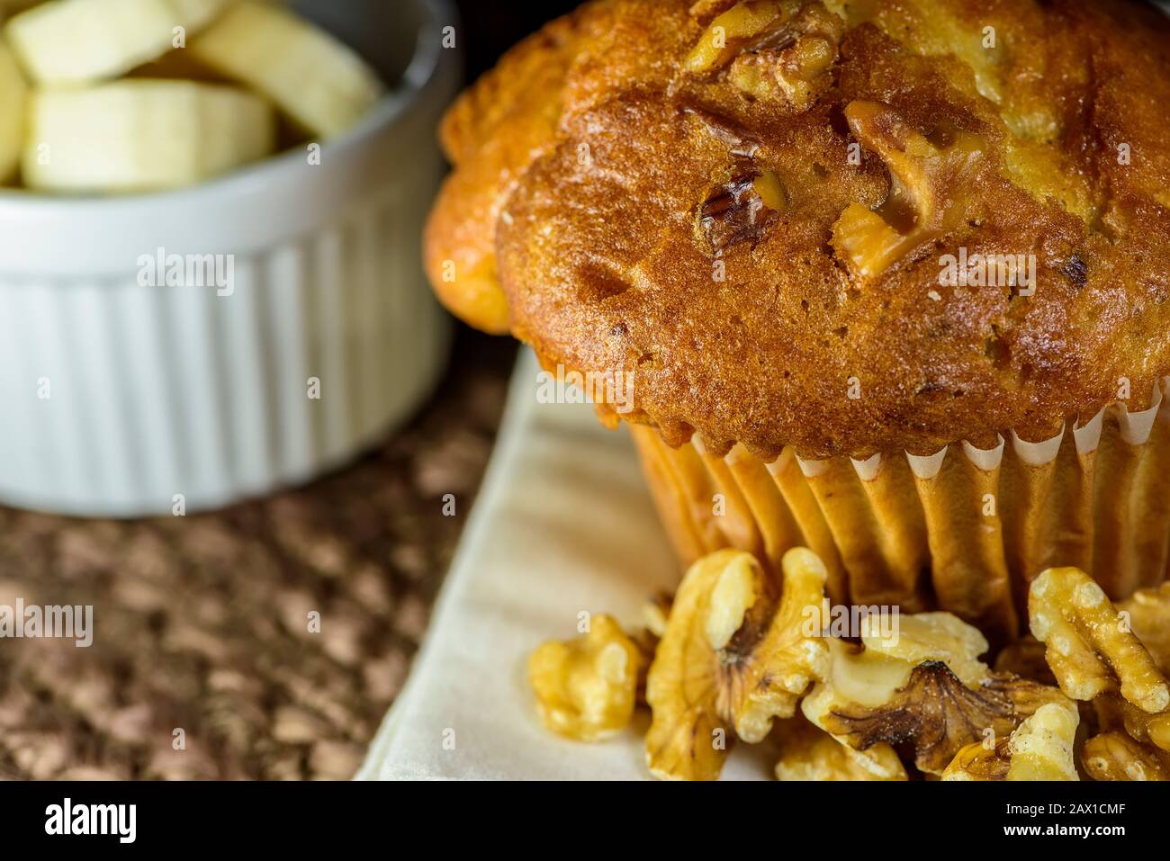 Muffin de Noix de banane fraîches entouré de noix et de bananes tranchées. Banque D'Images