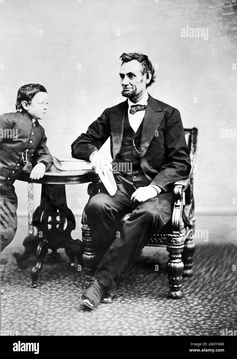 1865 , 5 février , États-Unis : Le président des États-Unis ABRAHAM LINCOLN ( Big South Fork , KY, 1809 - Washington 1865 ) . Photo d'Alexander GARDNER ( 1821 - 1882 ). Photo de la dernière séance officielle de portrait, le 5 février 1865, à Washington, D.C. O dix semaines avant l'assassinat du président. Lincoln, assis et tenant un livre, avec son fils Tad ( Thomas ) Penchant sur une table - Presidente della Repubblica - Stati Uniti - USA - ritratto - portrait - cravatta - tie - papillon - col - coletto - Abramo - padre e figlio - père et fils - libro - livre ---- Archivio GBB Banque D'Images