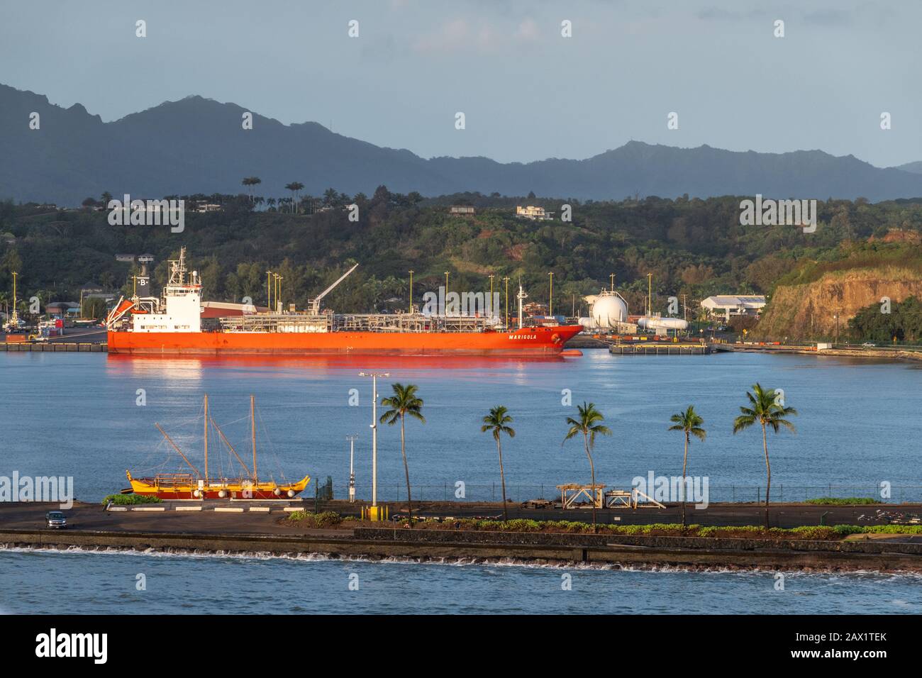 Nawiliwili, Kauai, Hawaï, États-Unis. - 16 janvier 2020: Feu de tôt le matin sur le camion-citerne GPL Marigola rouge dans le port sous ciel bleu clair. Ceinture verte en pente. B Banque D'Images