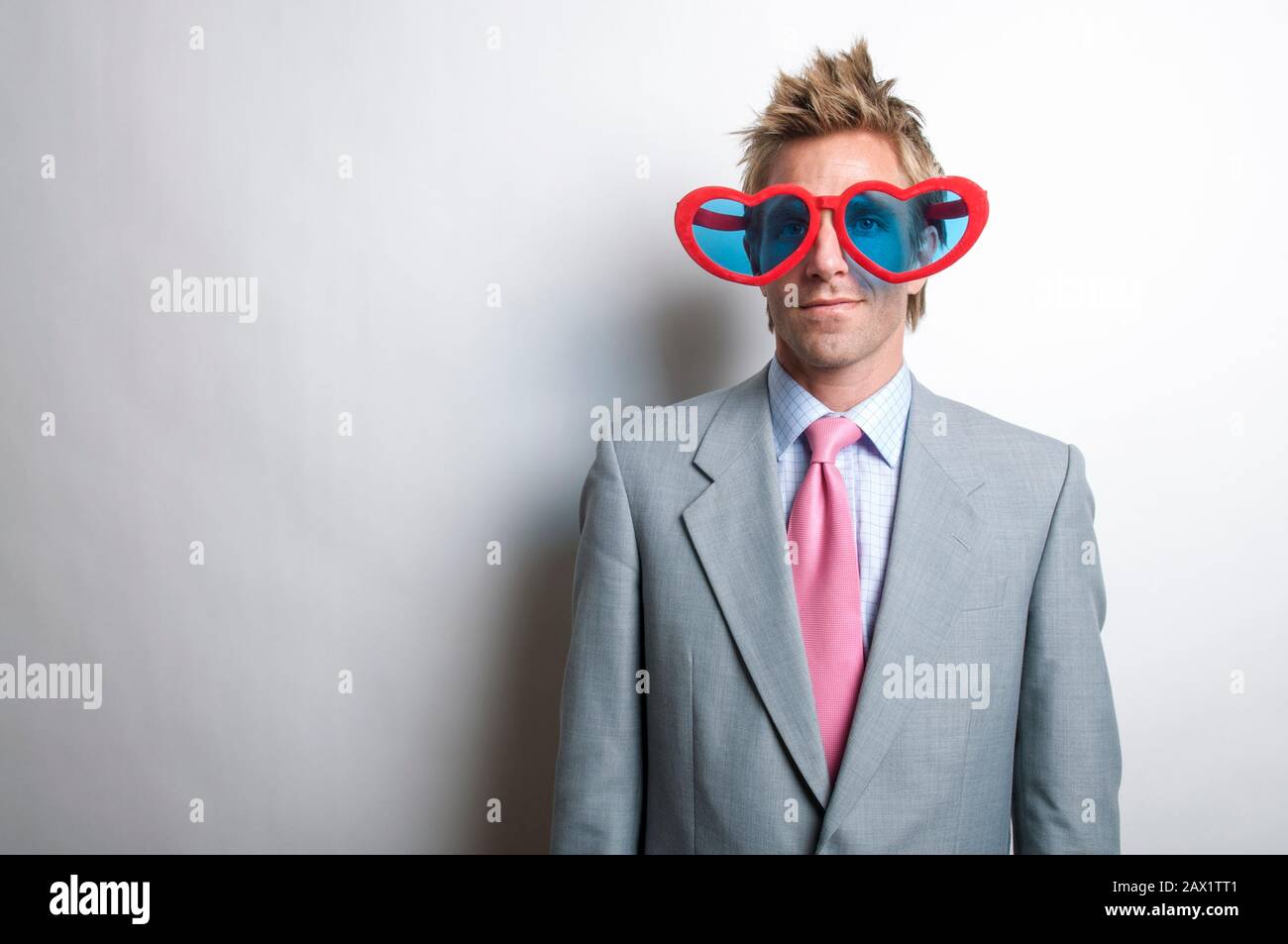 Portrait du travailleur de bureau portant des lunettes de Saint-Valentin au coeur rouge surdimensionné Banque D'Images