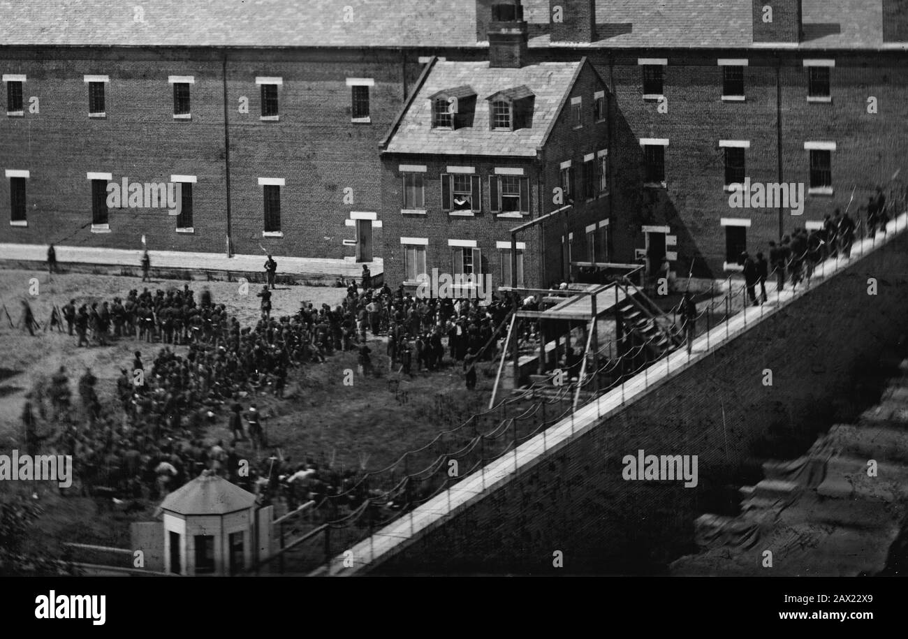 1865, 7 juillet , Navy Yard , WASHINGTON , D.C., États-Unis : exécution des conspirateurs: Échafaudage en usage et foule dans la cour, vu du toit de l'Arsenal . Les quatre conspirateurs condamnés Mme Mary Surratt ( 1820 - 1865 ), Lewis Powell âgé de 21 ans ( alias Lewis Payne ou Paine , 1844 - 1865 ) , David E. Herold et George A. Atzerodt le jour de la pendaison . Mary Surratt devient la première femme exécutée par le gouvernement fédéral des États-Unis. Le président américain ABRAHAM LINCOLN ( 1809 - 1865 ), mort le 15 avril 1865 . Photo d'Alexander GARDNER ( 1821 - 1882 ). - Président della Repu Banque D'Images